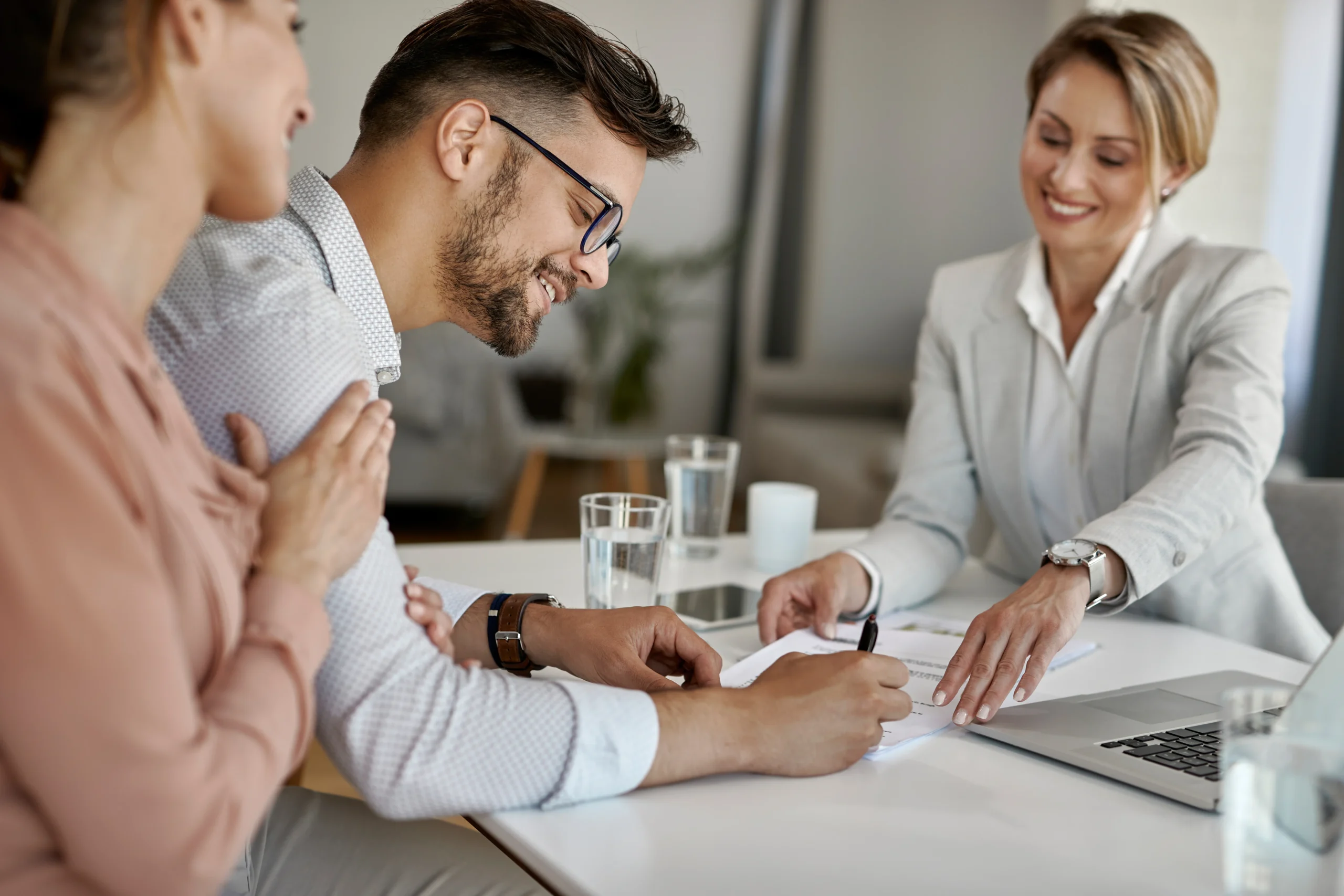 happy-man-his-wife-having-meeting-with-financial-advisor-signing-agreement-office