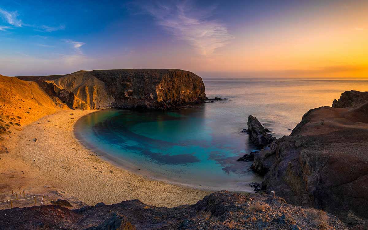 playa volcánica en Lanzarote al atardecer
